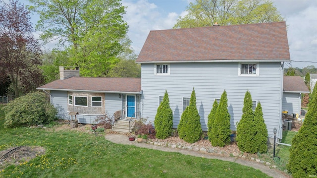 view of front of house featuring a chimney and roof with shingles