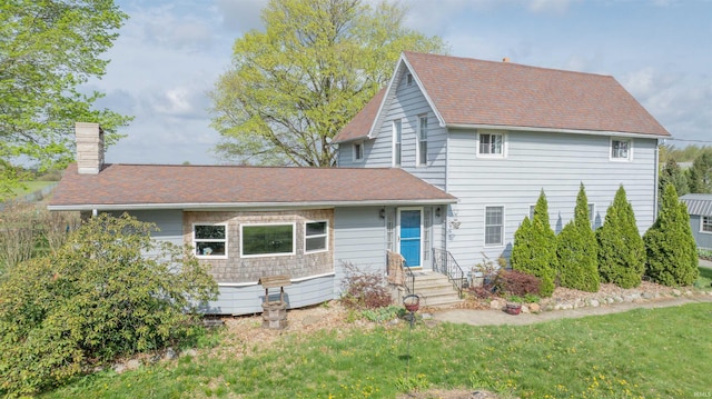 view of front of property featuring a chimney and a front yard