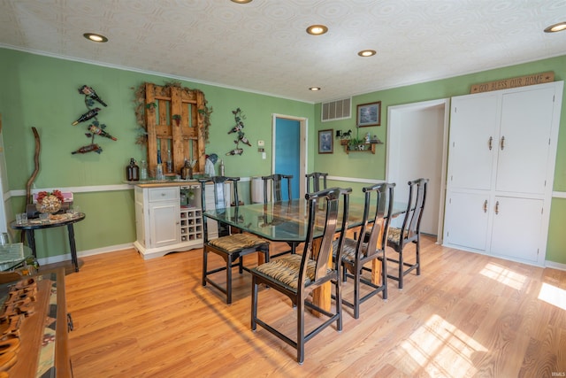 dining area with light wood-type flooring, an ornate ceiling, ornamental molding, recessed lighting, and baseboards