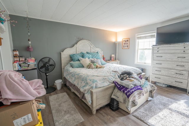 bedroom with wood finished floors and crown molding