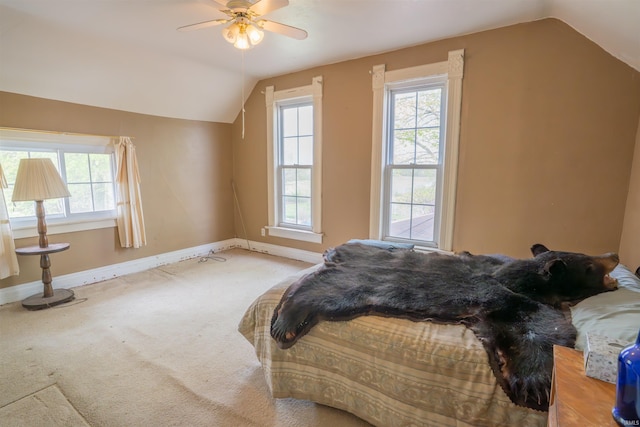bedroom with vaulted ceiling, baseboards, multiple windows, carpet flooring, and ceiling fan
