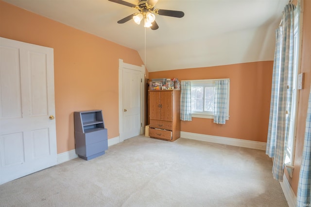 unfurnished bedroom featuring carpet floors, lofted ceiling, baseboards, and ceiling fan