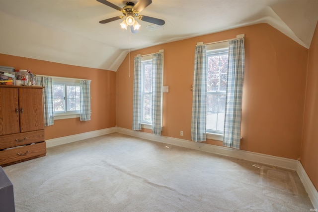 additional living space with vaulted ceiling, carpet floors, plenty of natural light, and a ceiling fan