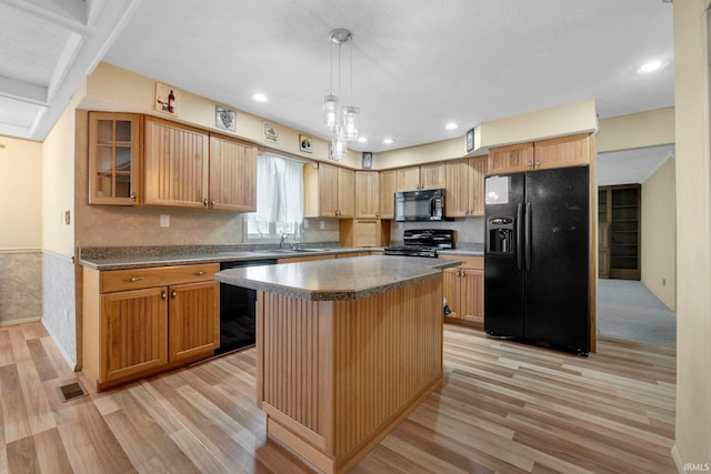 kitchen with black appliances, a sink, light wood-style flooring, dark countertops, and recessed lighting