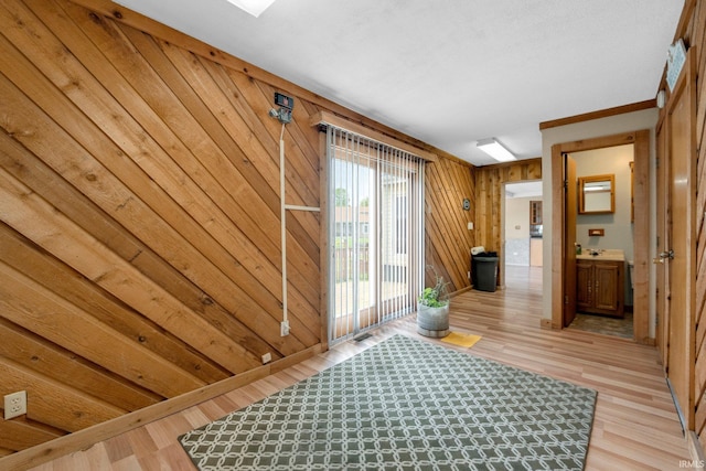 corridor featuring light wood-style flooring and wooden walls