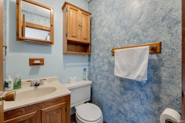 bathroom featuring toilet and vanity