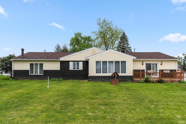 back of property with a wooden deck, a yard, roof with shingles, and brick siding