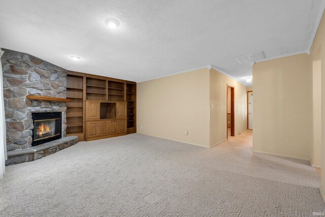 unfurnished living room with baseboards, a fireplace, ornamental molding, carpet, and a textured ceiling