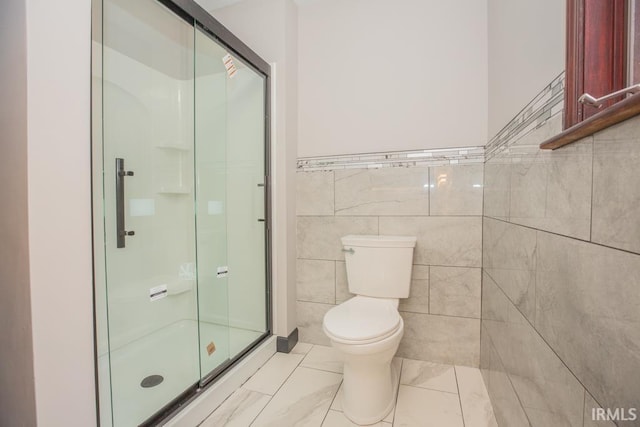 6318 Peacock Ln, Evansville, IN 47715 - bathroom with a stall shower, tile walls, toilet, marble look tile flooring, and a wainscoted wall