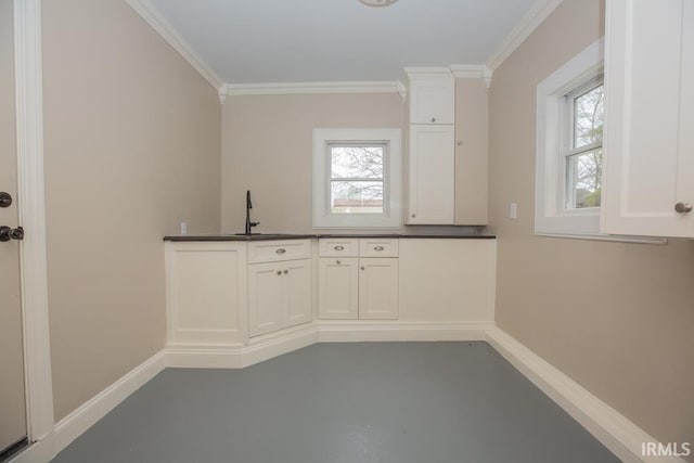 6318 Peacock Ln, Evansville, IN 47715 - kitchen featuring finished concrete floors, crown molding, plenty of natural light, baseboards, and dark countertops