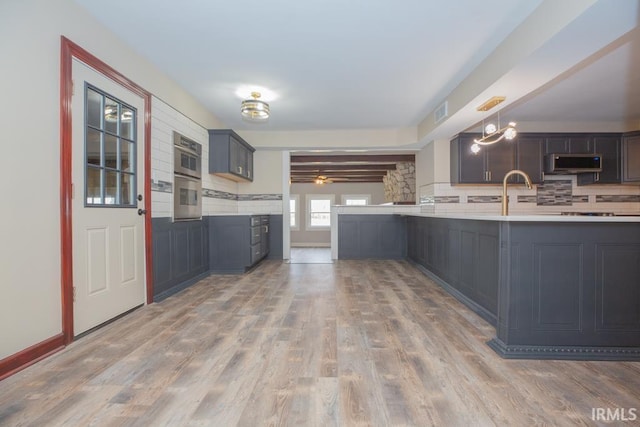 6318 Peacock Ln, Evansville, IN 47715 - kitchen featuring stainless steel appliances, backsplash, wood finished floors, light countertops, and a ceiling fan