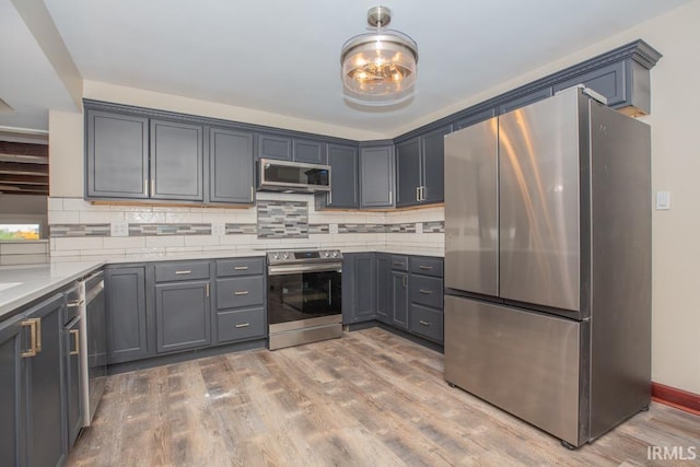 6318 Peacock Ln, Evansville, IN 47715 - kitchen with appliances with stainless steel finishes, light wood-style floors, backsplash, and light countertops