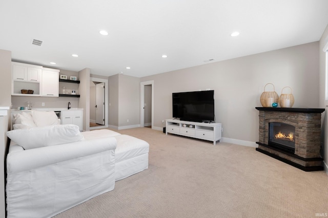 874 Cascata Trl, Huntertown, IN 46748 - living area featuring wet bar, recessed lighting, light carpet, a stone fireplace, and baseboards
