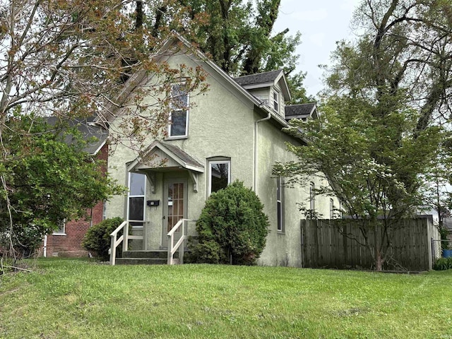 traditional-style house featuring stucco siding and a front lawn