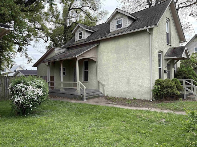 view of front of property featuring stucco siding, covered porch, and roof with shingles