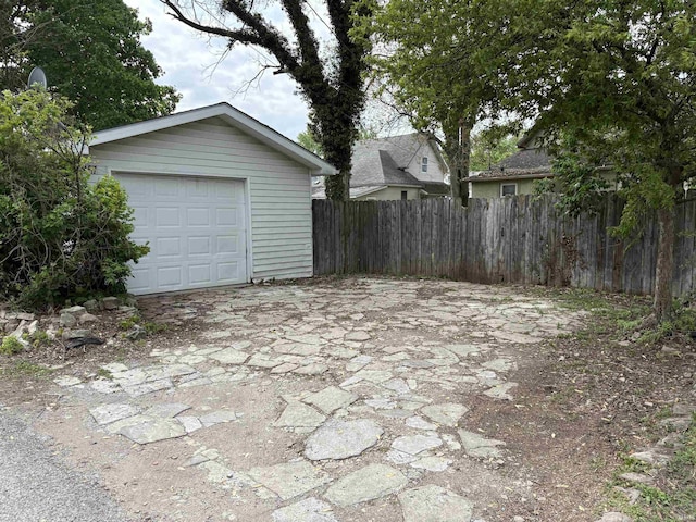 detached garage with fence and driveway