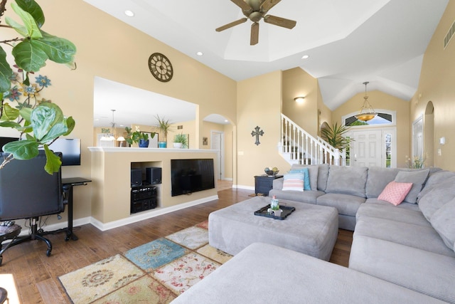 3090 Kellygreen Dr, Angola, IN 46703 - living area featuring arched walkways, ceiling fan, high vaulted ceiling, wood finished floors, and stairway