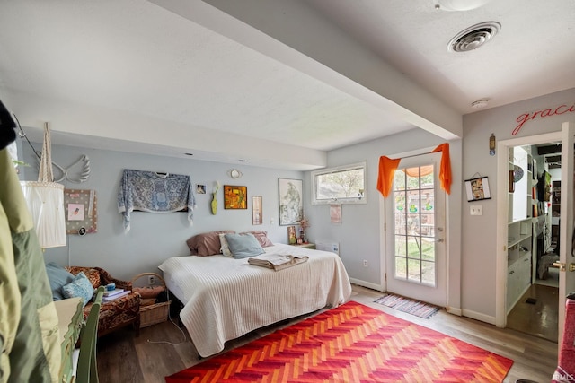 bedroom featuring access to outside, wood finished floors, and baseboards