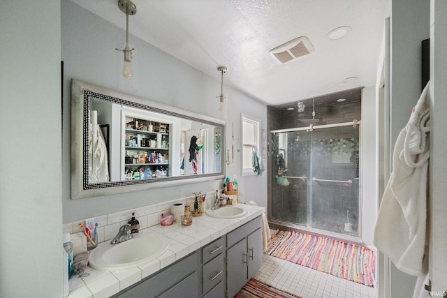bathroom featuring a shower stall, double vanity, backsplash, and tile patterned floors