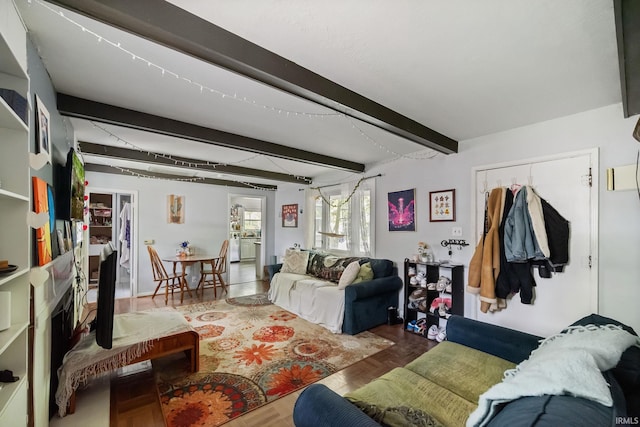 living area with beam ceiling and wood finished floors