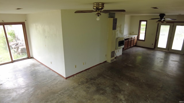 3927 E Driftwood Loop, Monticello, IN 47960 - unfurnished living room featuring a ceiling fan, concrete flooring, baseboards, and a heating unit