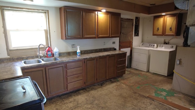 3927 E Driftwood Loop, Monticello, IN 47960 - kitchen with independent washer and dryer, range with electric stovetop, a sink, brown cabinetry, and light floors