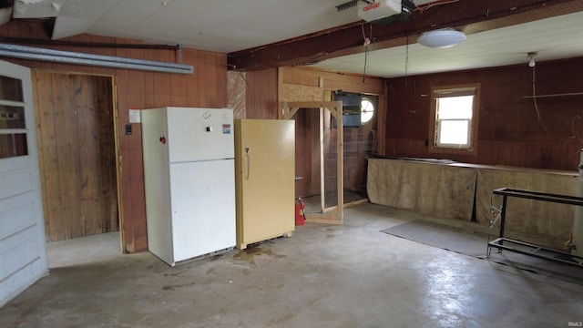 3927 E Driftwood Loop, Monticello, IN 47960 - kitchen with freestanding refrigerator, concrete flooring, and wood walls