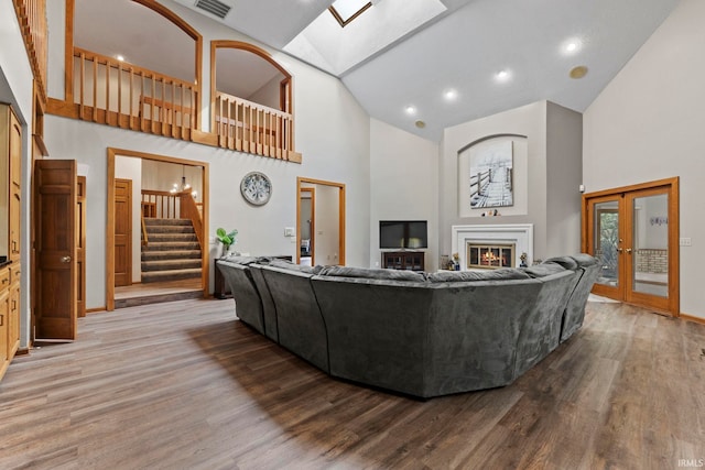 15 Saint Emily Dr, Huntington, IN 46750 - living area featuring high vaulted ceiling, a skylight, stairway, wood finished floors, and a glass covered fireplace