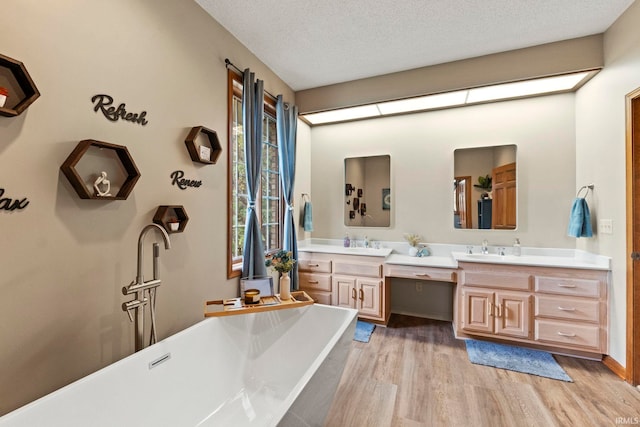 15 Saint Emily Dr, Huntington, IN 46750 - full bathroom featuring wood finished floors, vanity, a freestanding bath, and a textured ceiling