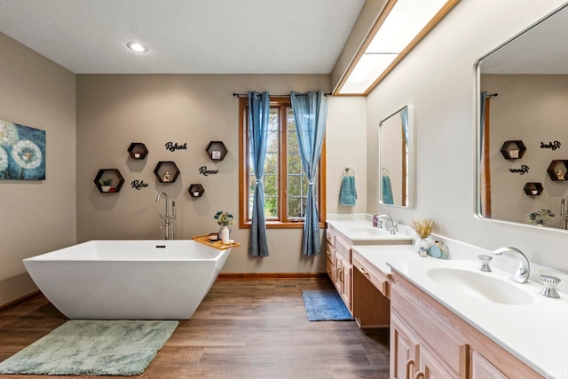 15 Saint Emily Dr, Huntington, IN 46750 - full bath featuring double vanity, a freestanding bath, wood finished floors, baseboards, and recessed lighting