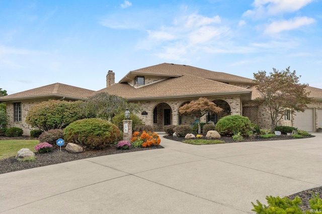 15 Saint Emily Dr, Huntington, IN 46750 - view of front of house featuring a chimney, driveway, brick siding, and an attached garage