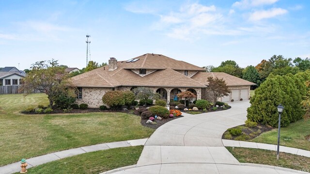 15 Saint Emily Dr, Huntington, IN 46750 - view of front of house with a front lawn, a garage, concrete driveway, and a chimney