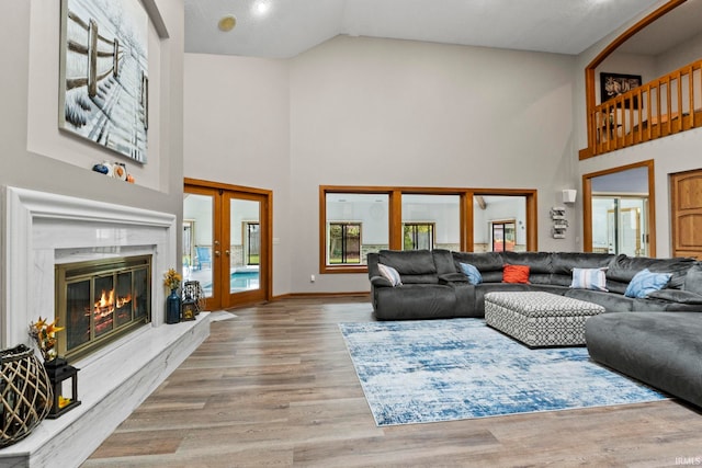 15 Saint Emily Dr, Huntington, IN 46750 - living area with high vaulted ceiling, french doors, wood finished floors, a high end fireplace, and baseboards