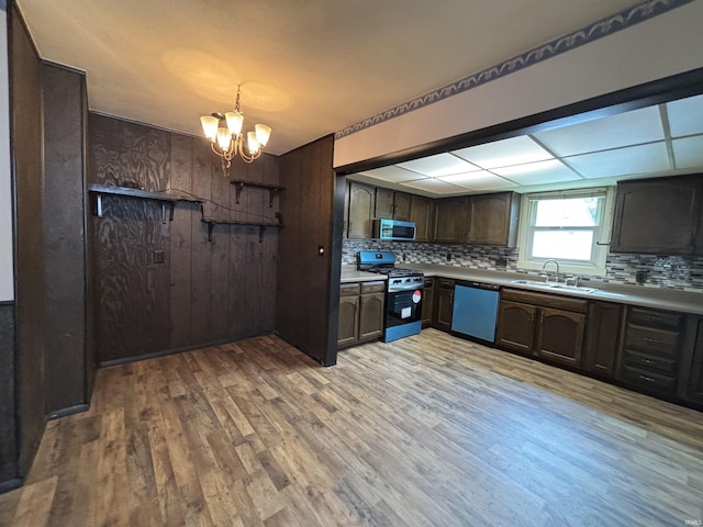 919 Kensington Blvd, Fort Wayne, IN 46805 - kitchen with appliances with stainless steel finishes, decorative backsplash, light wood finished floors, a chandelier, and a sink