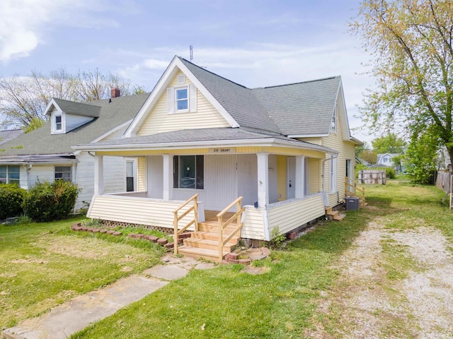 view of front of property with covered porch, central AC, roof with shingles, and a front lawn