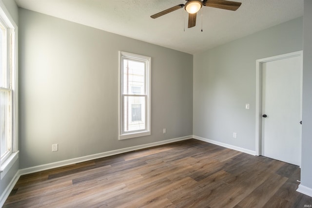 spare room featuring wood finished floors, ceiling fan, and baseboards