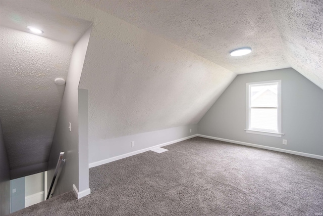 bonus room featuring a textured ceiling, vaulted ceiling, carpet, and baseboards