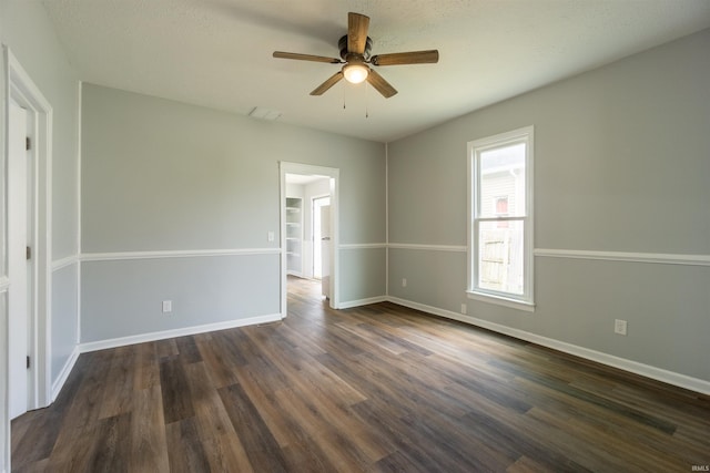 unfurnished room featuring ceiling fan, dark wood-style flooring, and baseboards