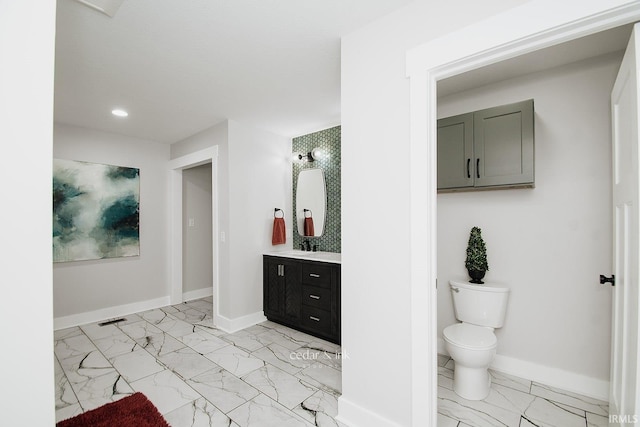 bathroom featuring marble look tile flooring, baseboards, vanity, toilet, and recessed lighting