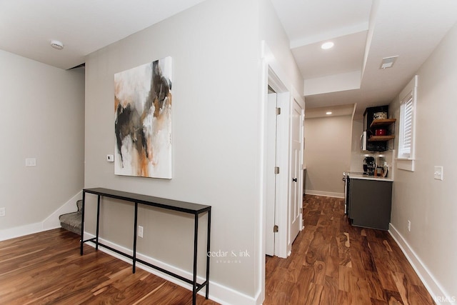 hall featuring wood finished floors, baseboards, stairway, and recessed lighting