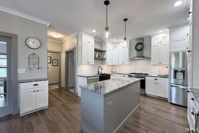kitchen with appliances with stainless steel finishes, wall chimney range hood, a sink, a kitchen island, and ornamental molding