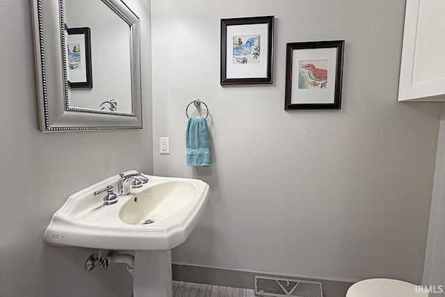 bathroom with baseboards and toilet