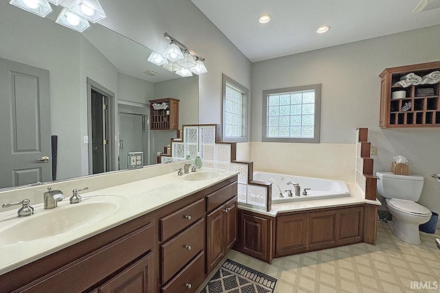 bathroom with tile patterned floors, a bath, toilet, double vanity, and recessed lighting