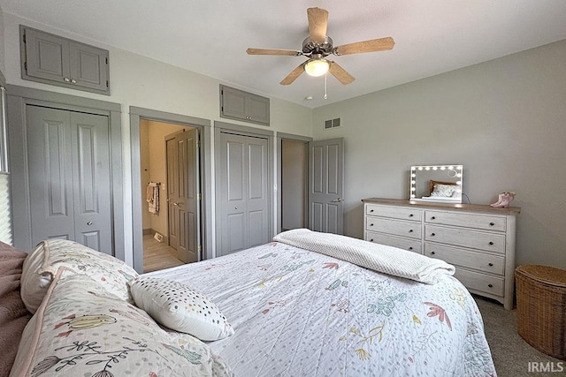 bedroom with two closets, carpet floors, and a ceiling fan