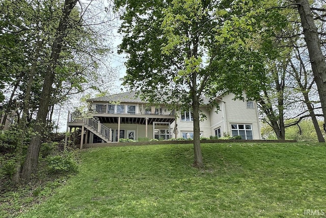 rear view of house with stairs, a wooden deck, and a lawn
