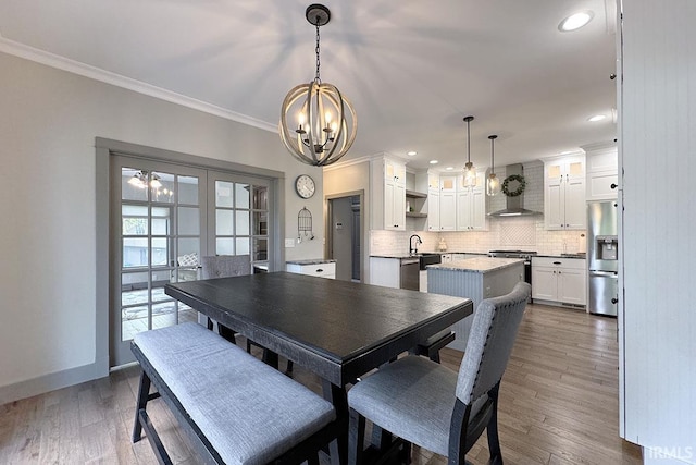 dining room with a chandelier, ornamental molding, dark wood-type flooring, recessed lighting, and baseboards