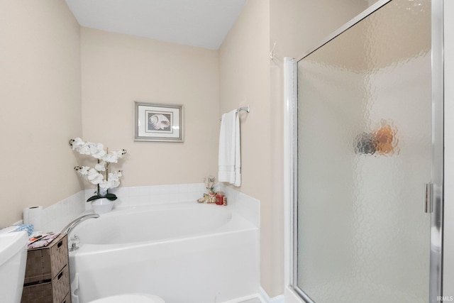 full bath with toilet, a garden tub, and a stall shower