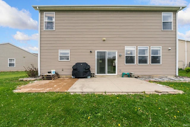 rear view of house featuring a lawn and a patio area