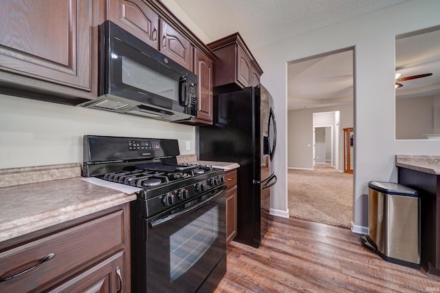 1592 Breckenridge Pass, Fort Wayne, IN 46845 - kitchen with black appliances, wood finished floors, light countertops, dark brown cabinets, and baseboards
