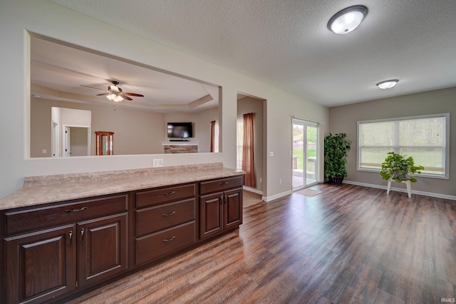 1592 Breckenridge Pass, Fort Wayne, IN 46845 - kitchen featuring open floor plan, wood finished floors, light countertops, dark brown cabinets, and a textured ceiling